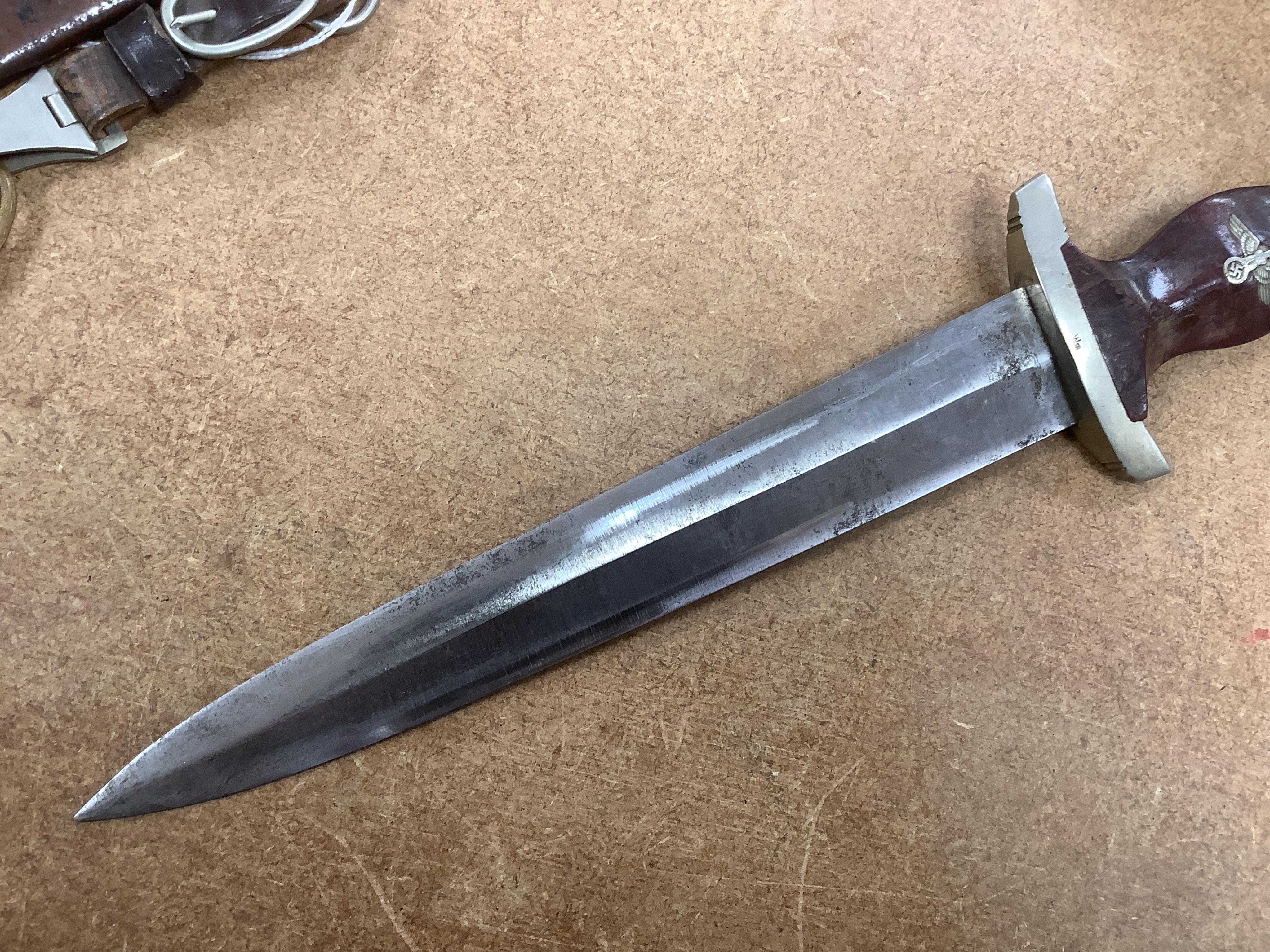 A WWII German SA dagger, regulation pattern in its steel scabbard with regulation nickel mounts, and leather hanging band and a German dress bayonet by Paul Seilheimer. Condition - fair, some wear